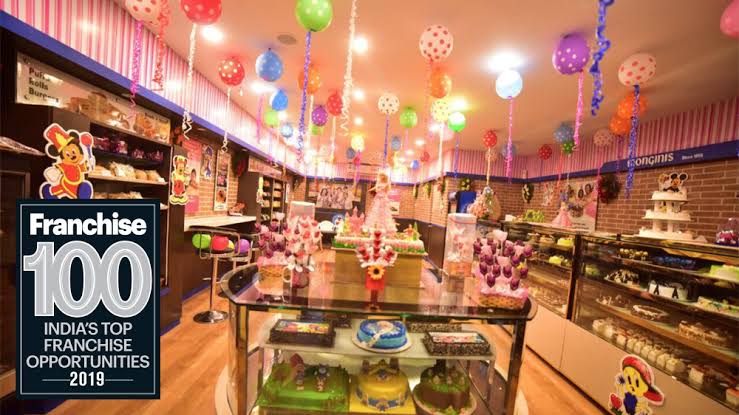 Shop decorated with balloons for a celebration, with a Franchise 100 badge